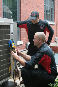 Northern Comfort Systems technicians performing an HVAC tune-up