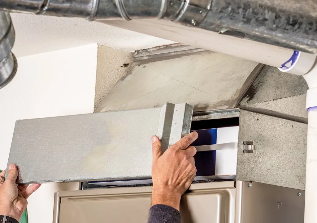 HVAC technician removing the furnace filter cover