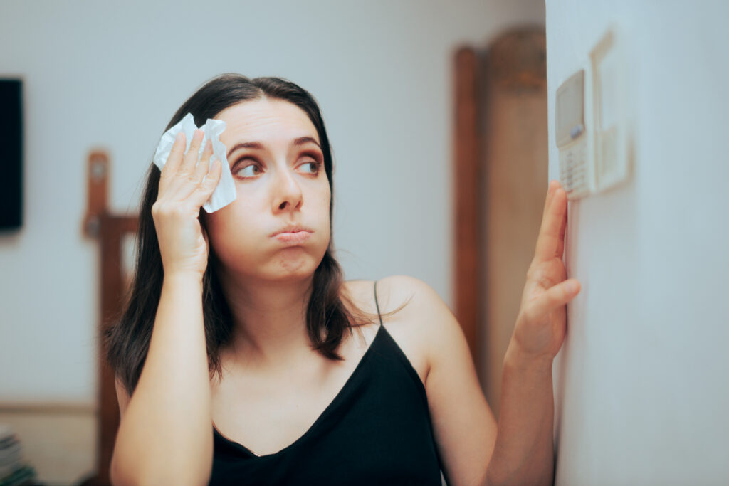 Woman in front of AC thermostat
